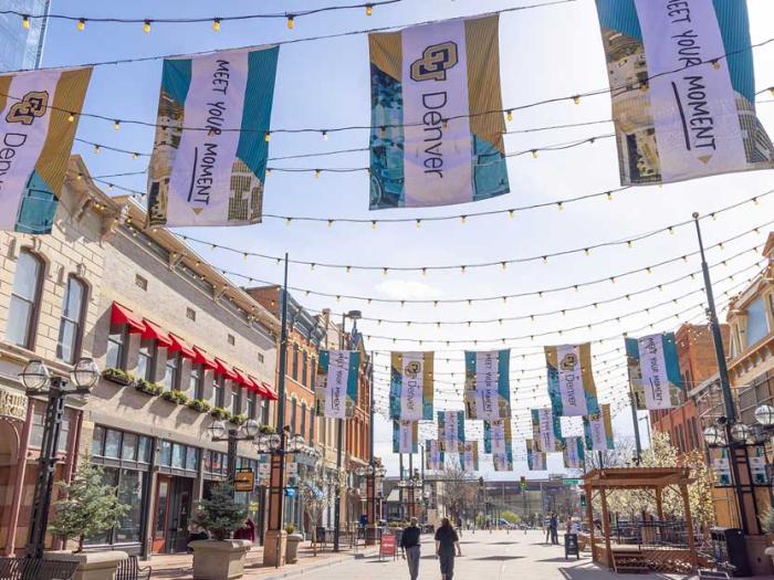Stylistic shot of CU Denver branded flags hanging above Larimer Square
