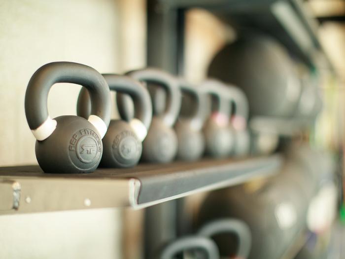 Stylistic shot of kettle bells lined up in a row on a shelf