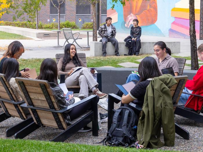 Group of CU Denver students sitting in a circle in adirondack chairs