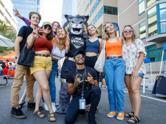 Group of CU Denver students at Block Party posing with mascot Milo