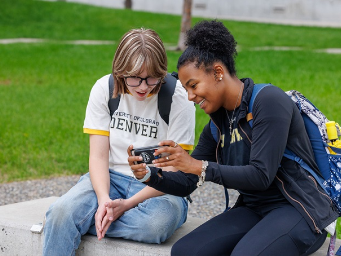 CU Denver students sharing a phone