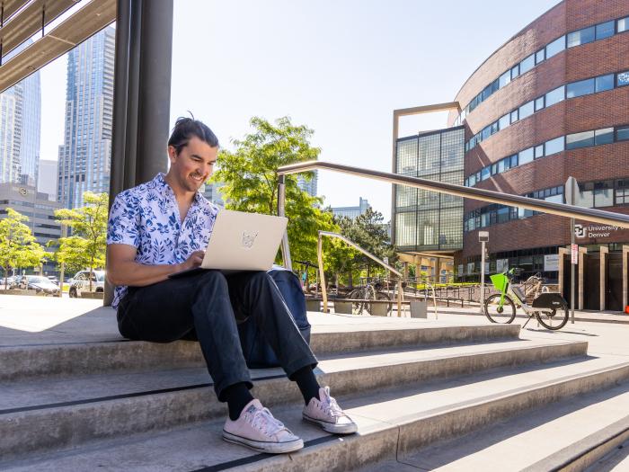 Student sitting on stairs outside building