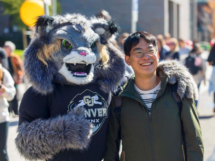 Student posing with CU Denver mascot