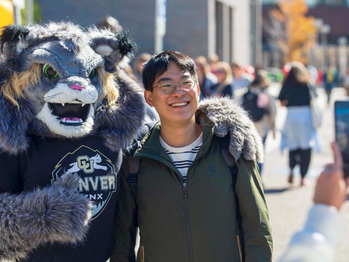 Student posing with CU Denver mascot