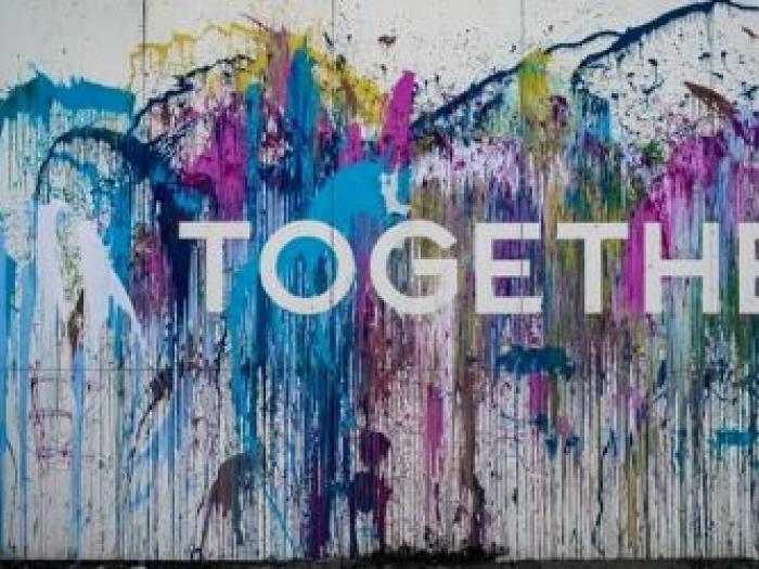 Mural of splatter paint with Together written in it. 