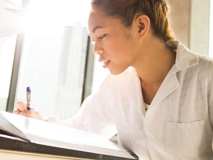 Student reading and taking notes in lab