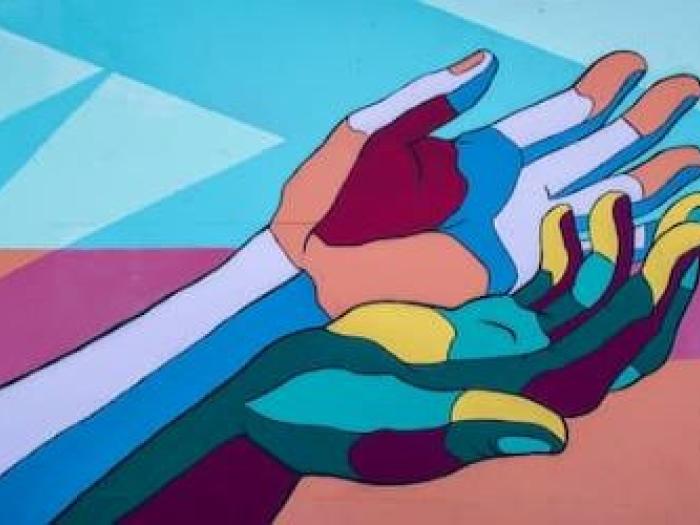 Mural of hands in different colors on wall