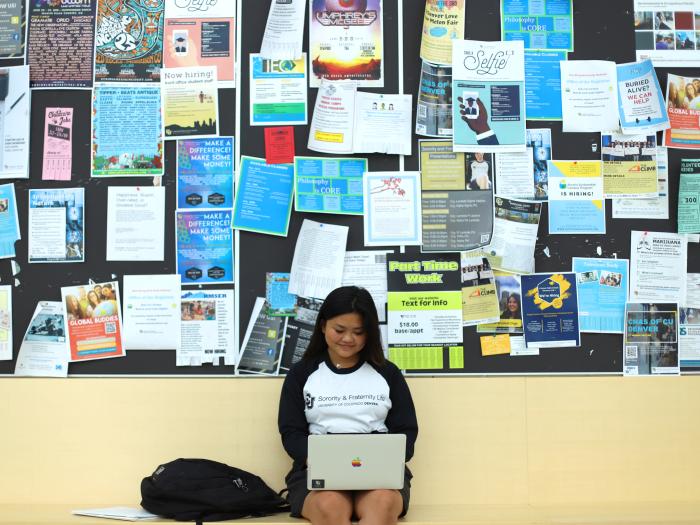 Student in front of wall of fliers