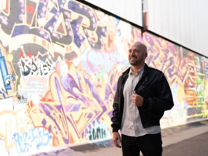 Man standing in front of wall with street art