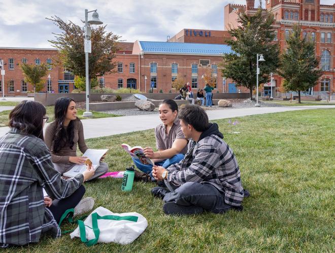 Students sitting on green in front of Tivoli building