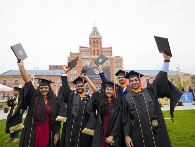 Group of graduates holding their diplomas up