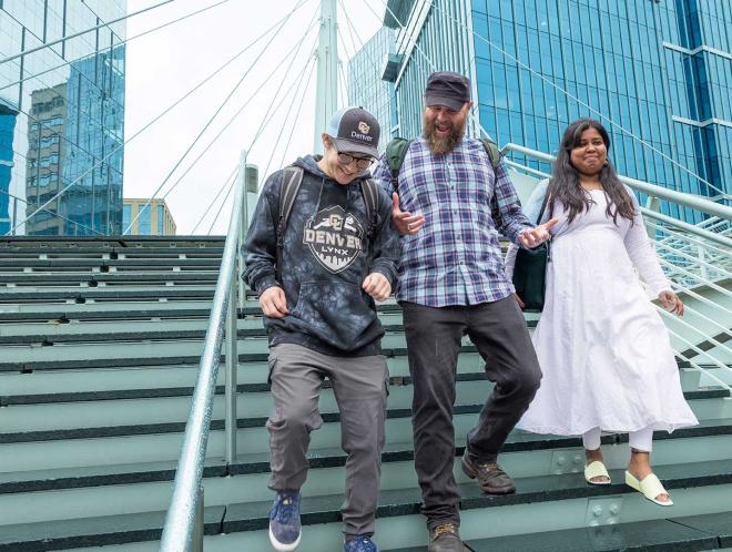 Three students walking down steps outside