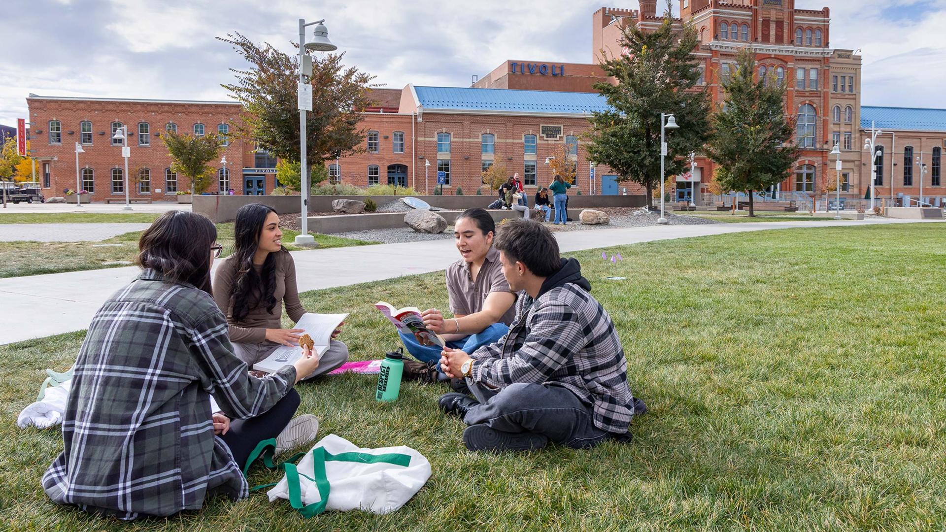 Students sitting on green in front of Tivoli building
