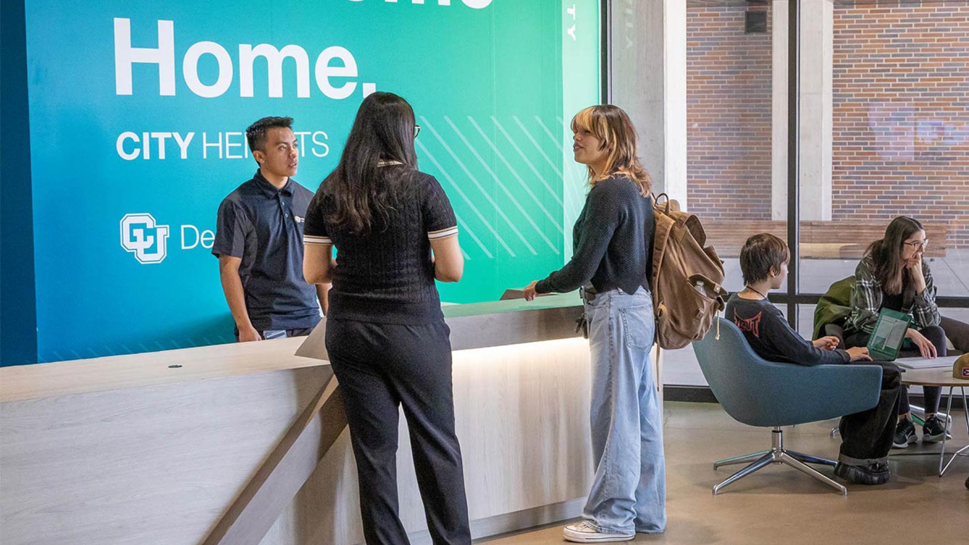 Students standing at counter in lobby of city heights