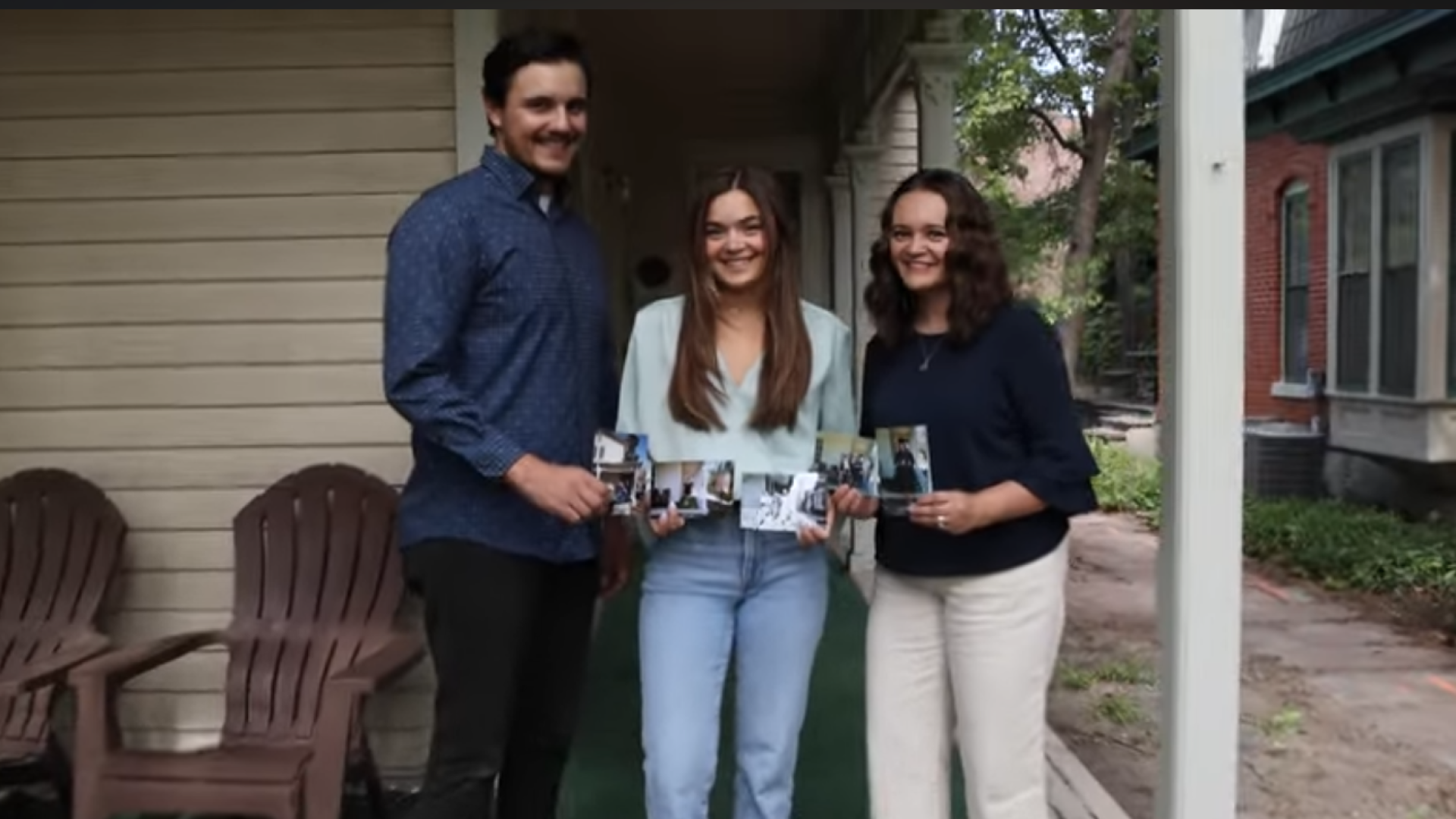 Three siblings, recipients of the Displaced Aurarian Scholarship, holding old family photos standing on porch