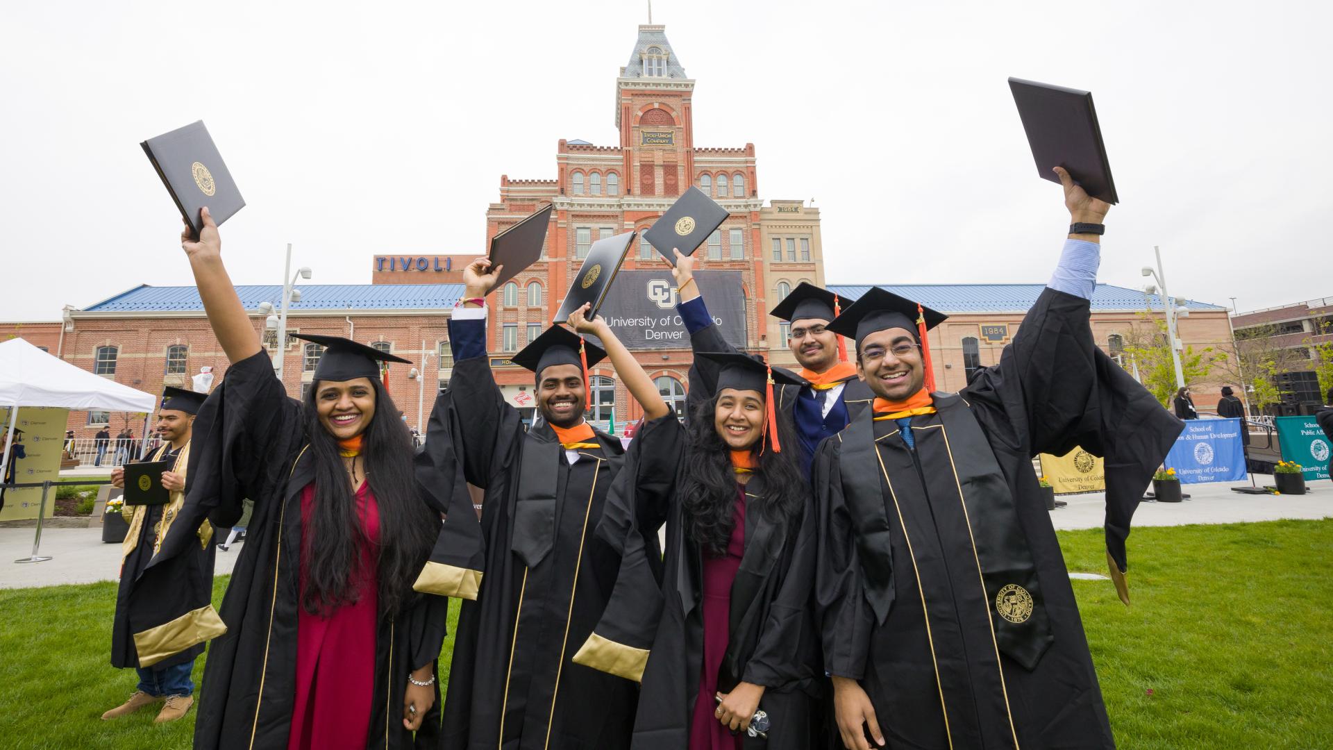 Group of graduates holding their diplomas up