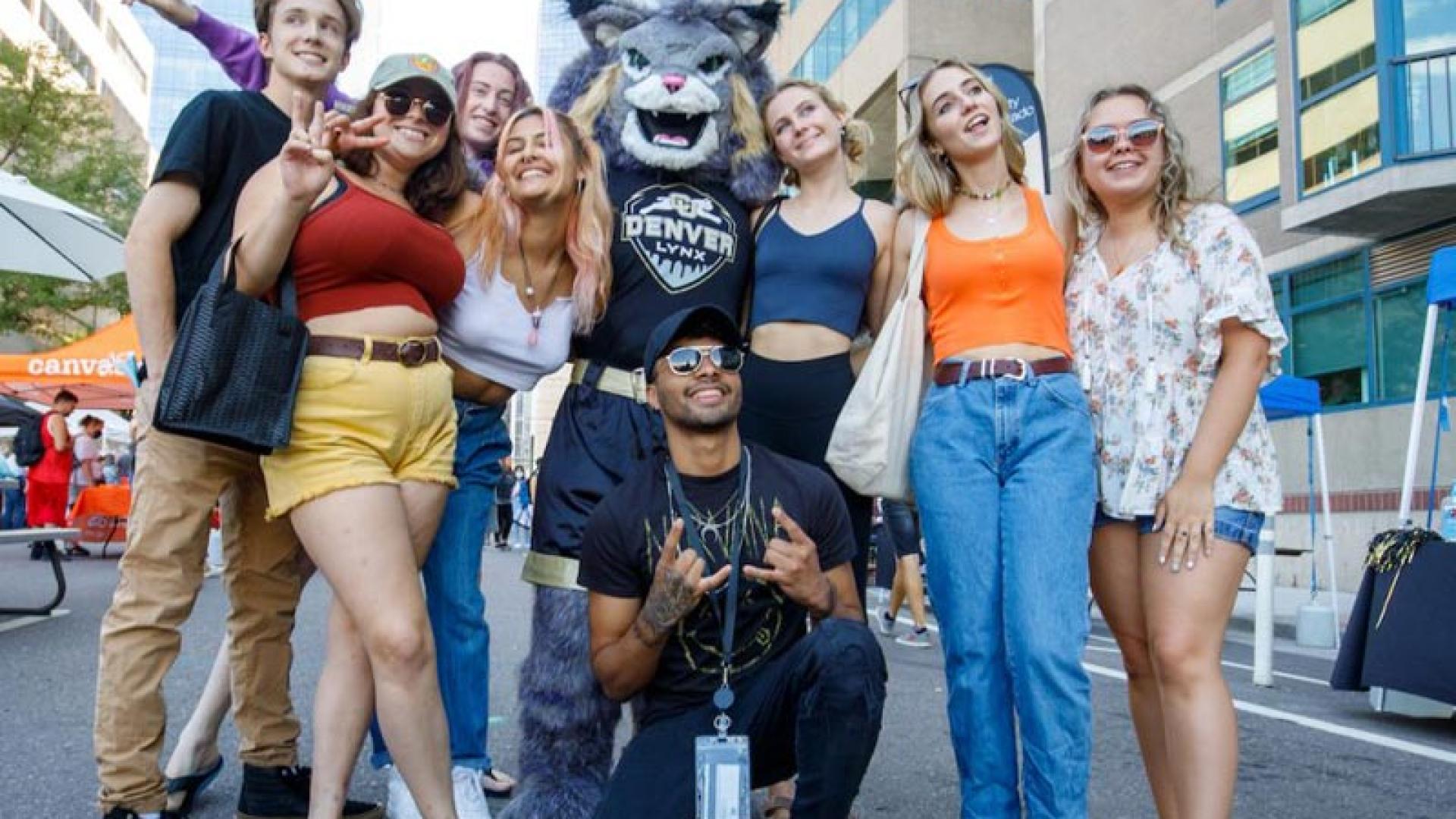Group of CU Denver students at Block Party posing with mascot Milo