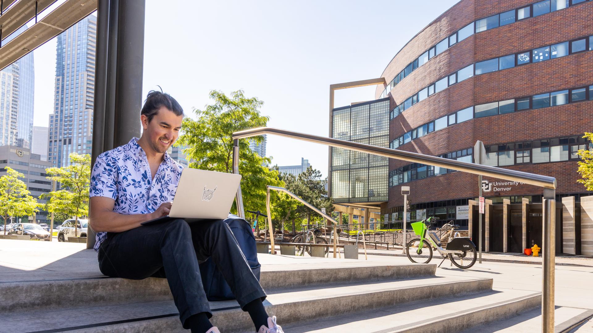 Student sitting on stairs outside building