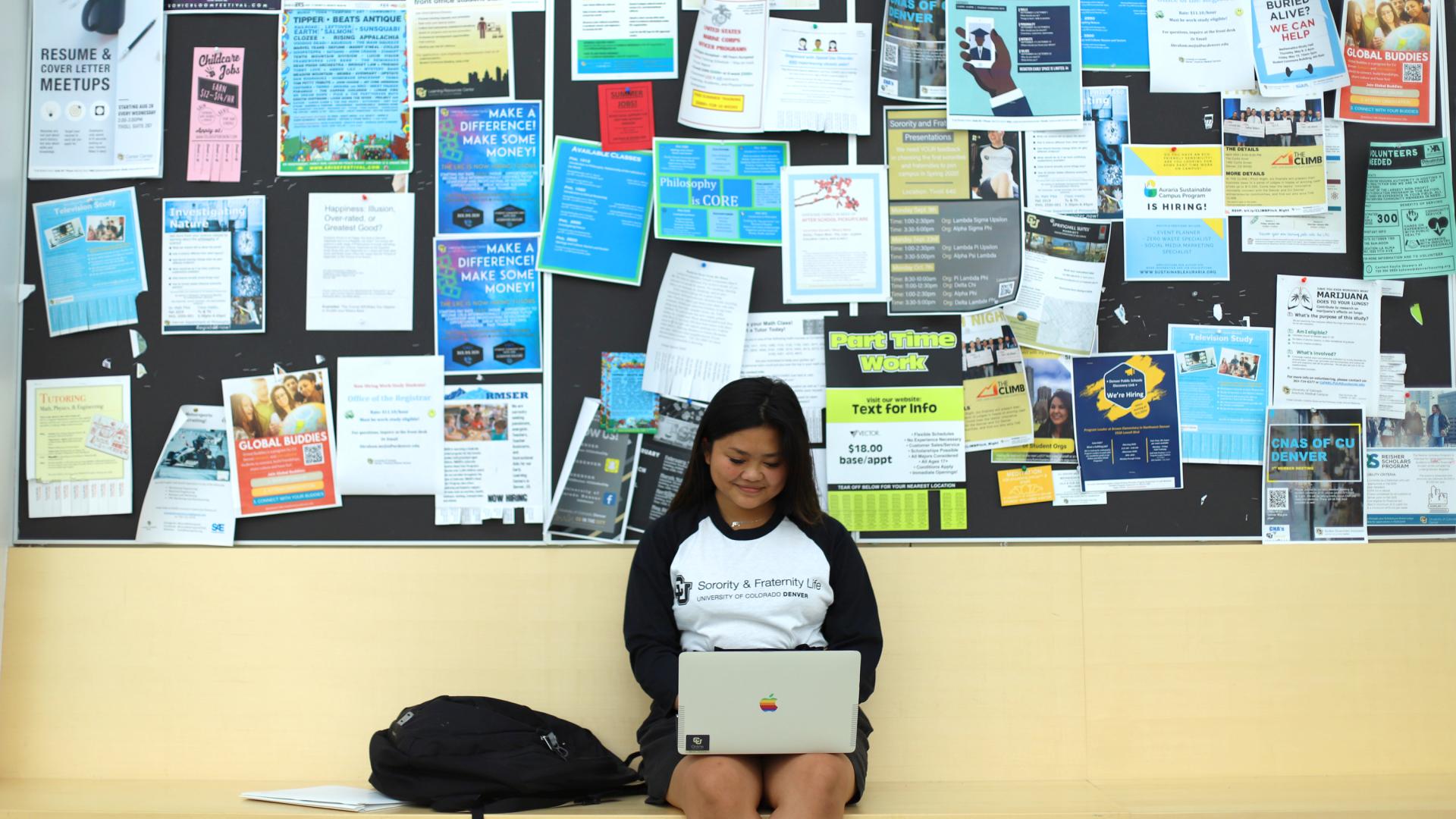 Student in front of wall of fliers