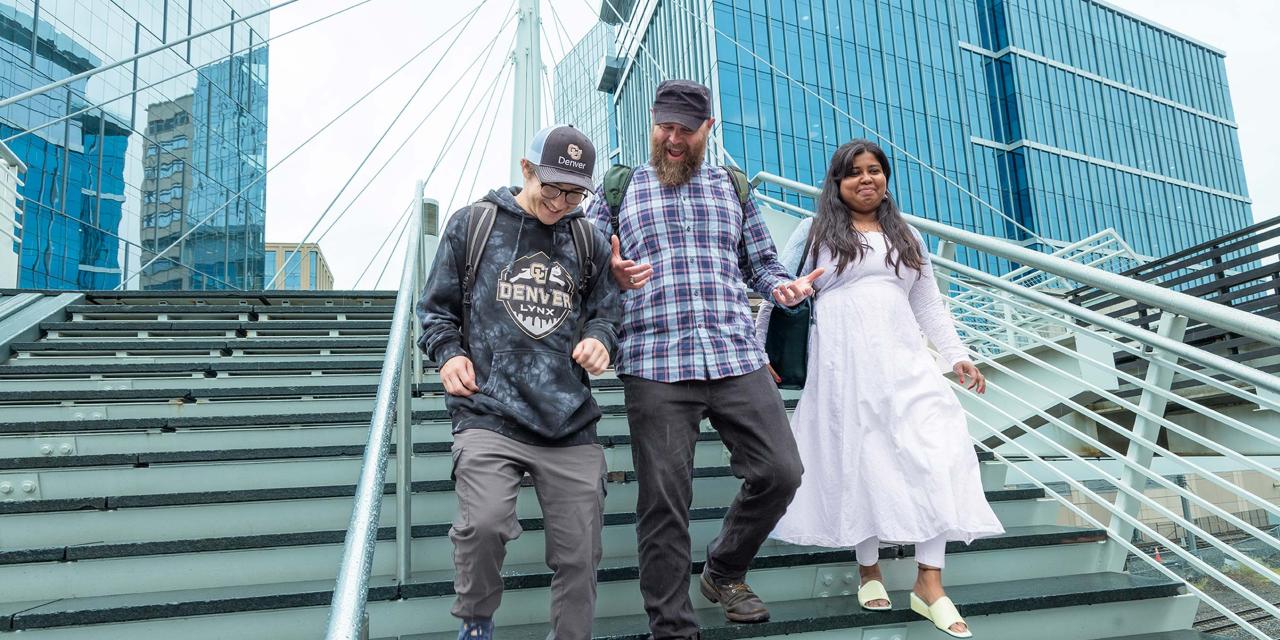Three CU Denver students walking down stairs outside