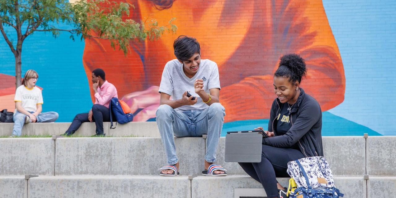 CU Denver students sitting on steps in front of building