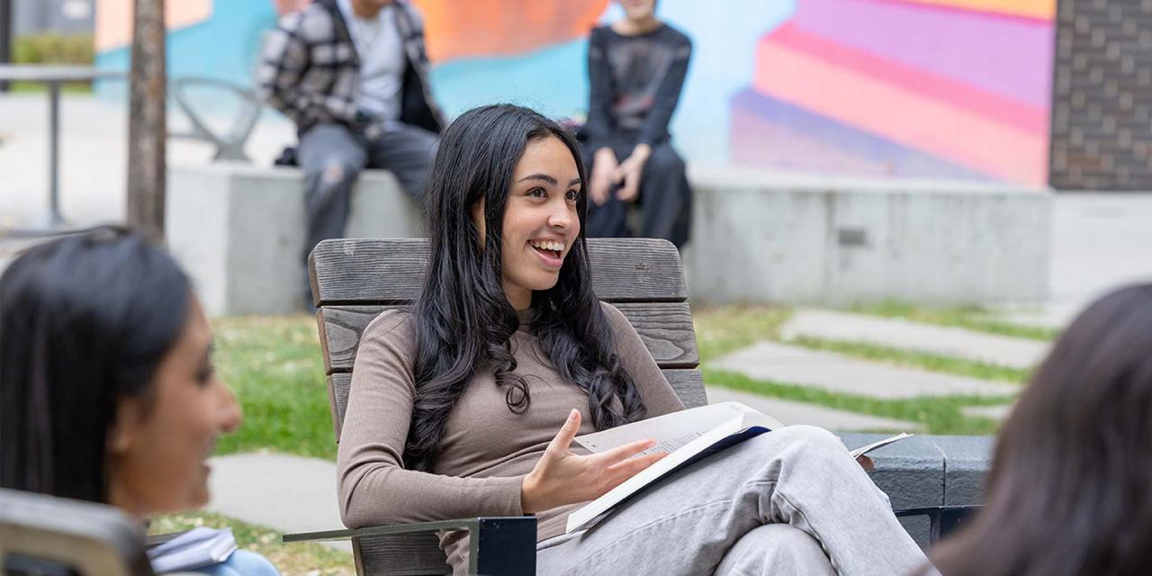 Students sitting outside in Adirondack chairs positioned in a circle