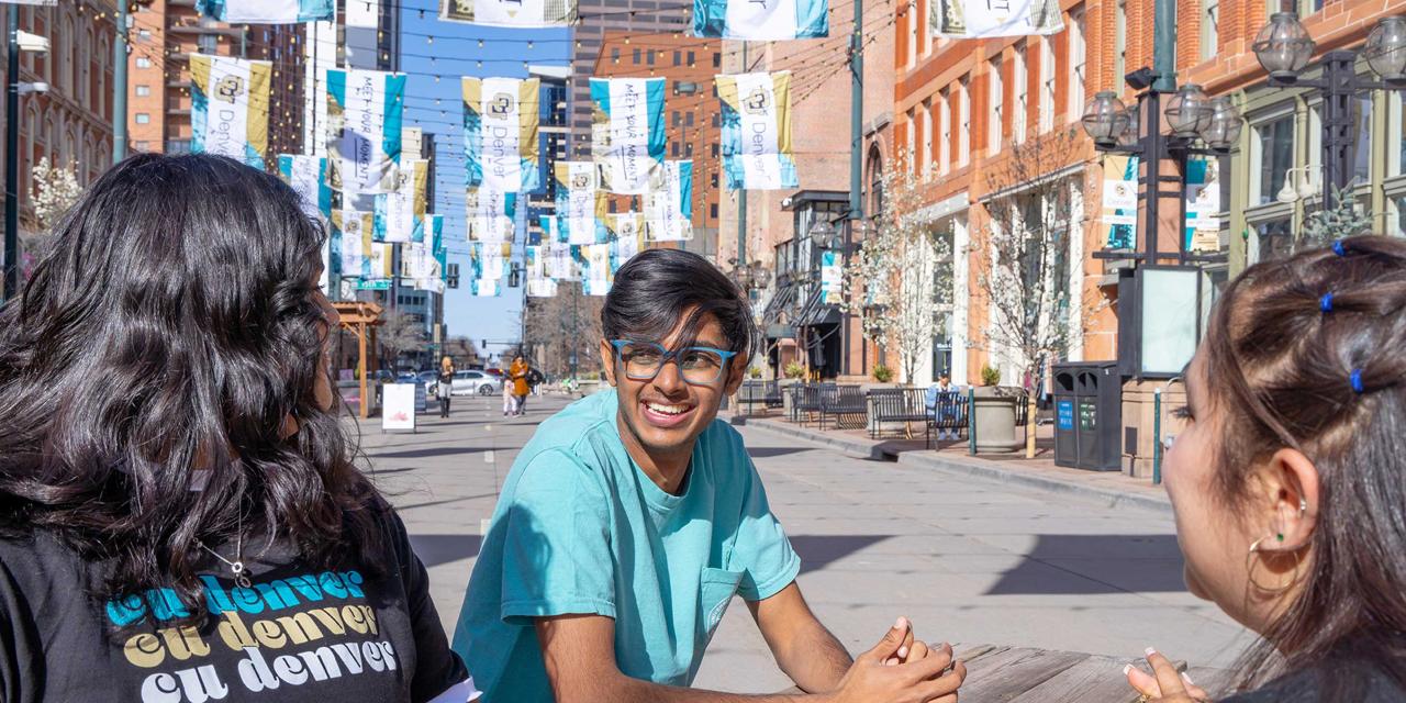 Three CU Denver students sit at picnic table in Larimer Square
