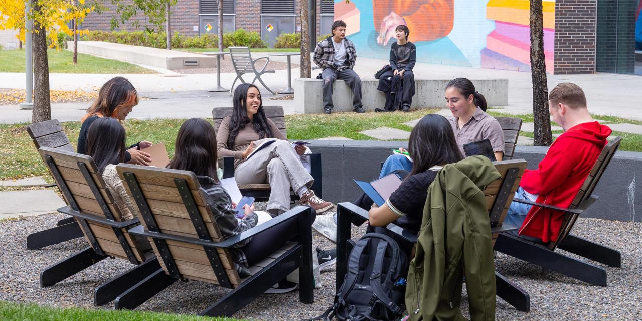 Group of CU Denver students sitting in a circle in adirondack chairs