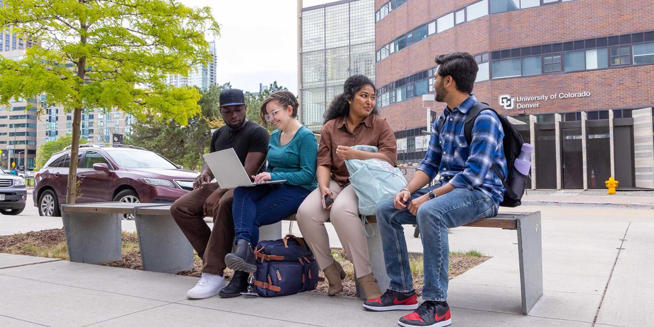 Four students sitting on bench having two separate conversations