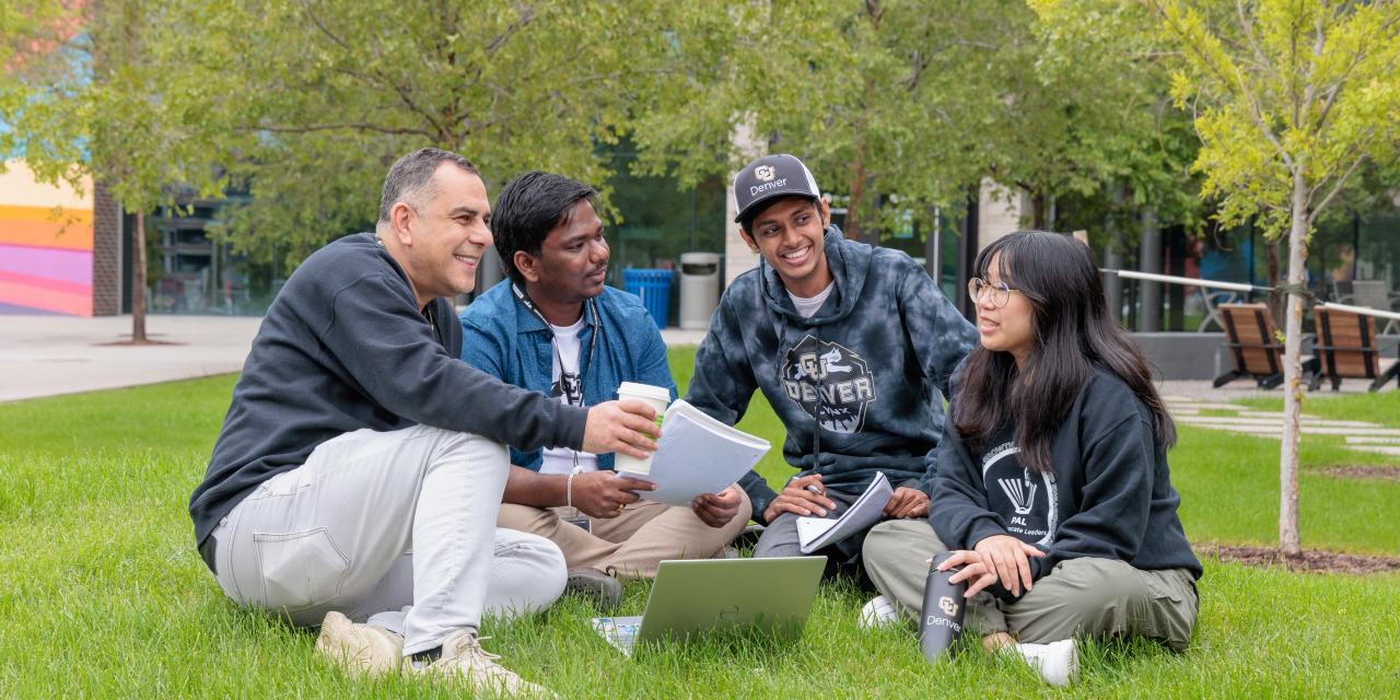 Students sitting on grass looking at notes