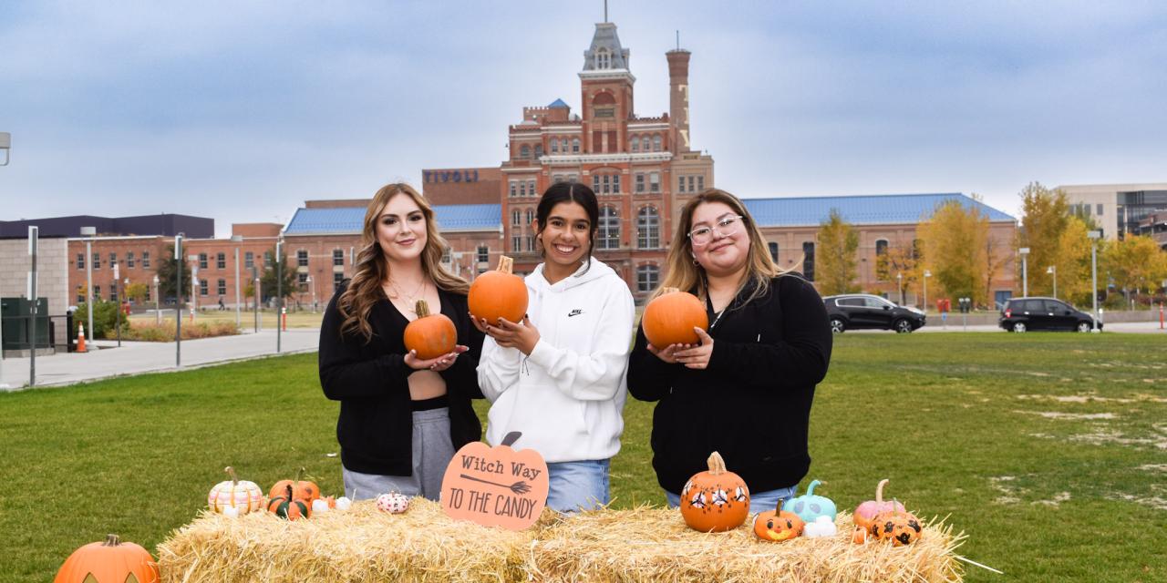 students-holding-pumpkins-outside-cat