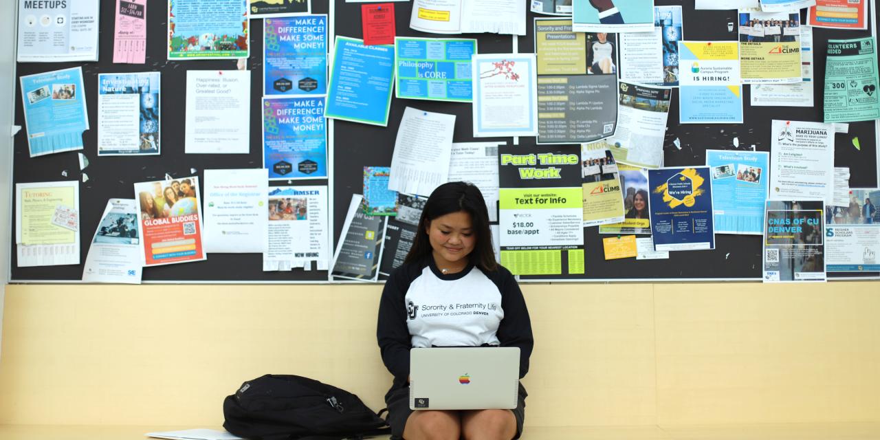 Student in front of wall of fliers