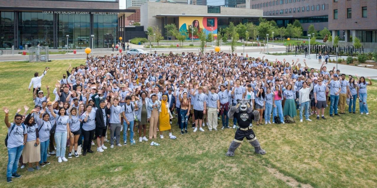 Large group of students at New Student Welcome posing with Milo on the campus green