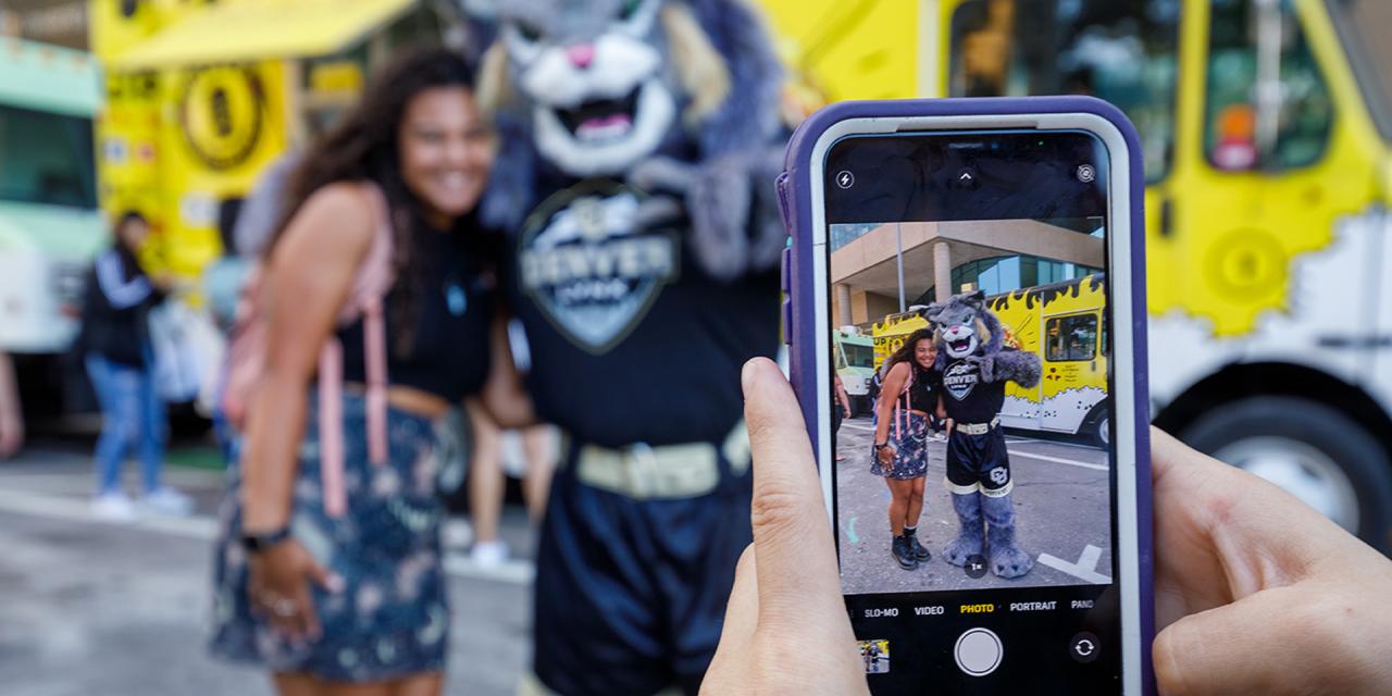 Phone in foreground taking picture of Milo with student