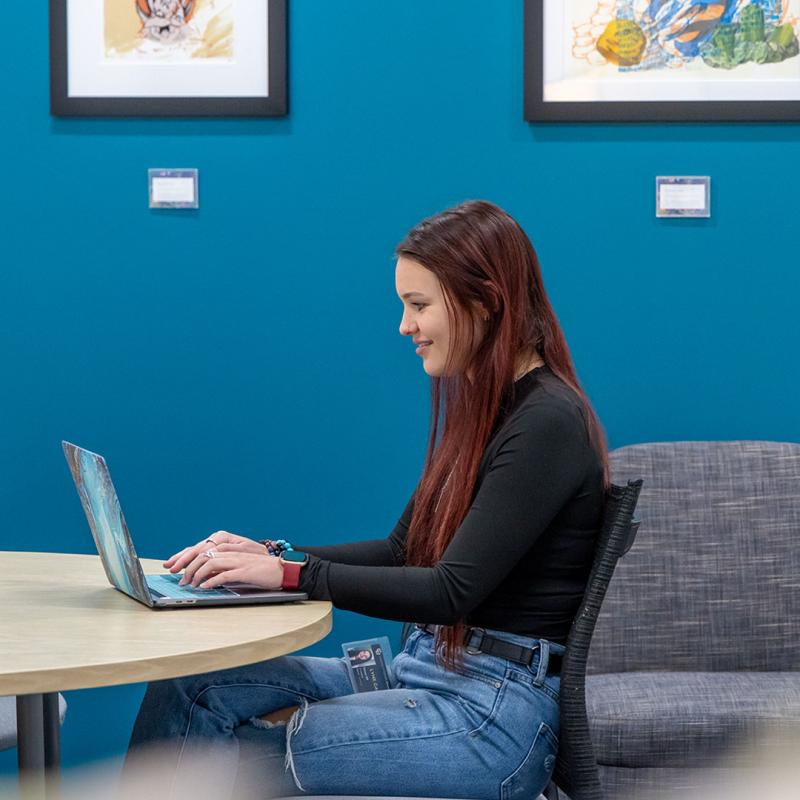 CU Denver student working on laptop in student center