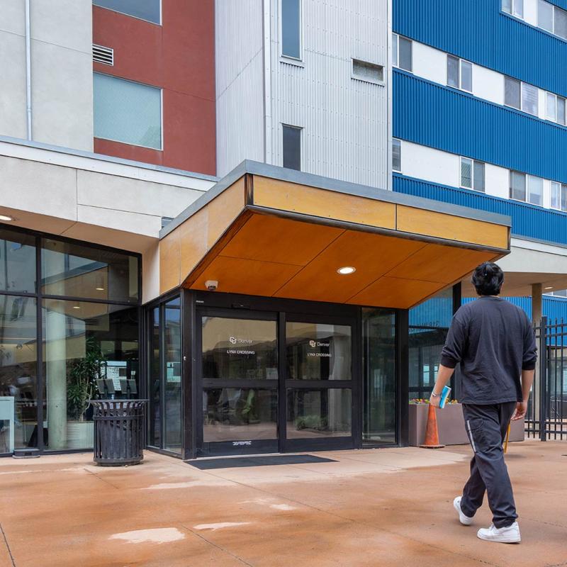 Student walking towards the front door of Lynx Crossing building