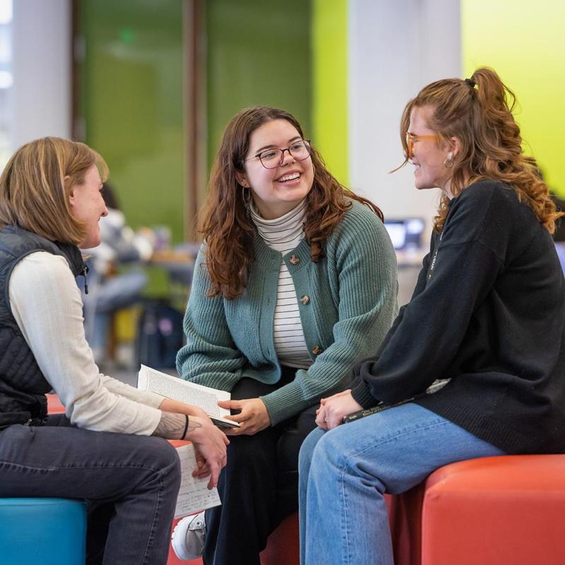 Three School of Education and Human Development students sitting together talking
