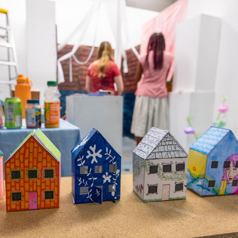 Decorated cardboard houses lined up in a row