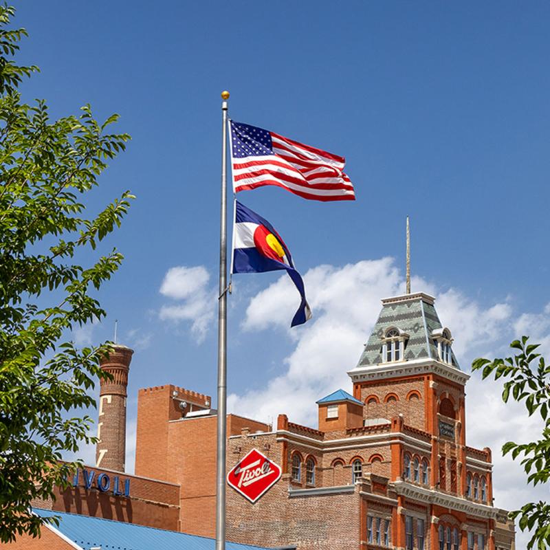 Colorado and American flag on flag pole in front of Tivoli Student Union