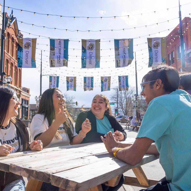Students sitting at picnic table in Larimer Square