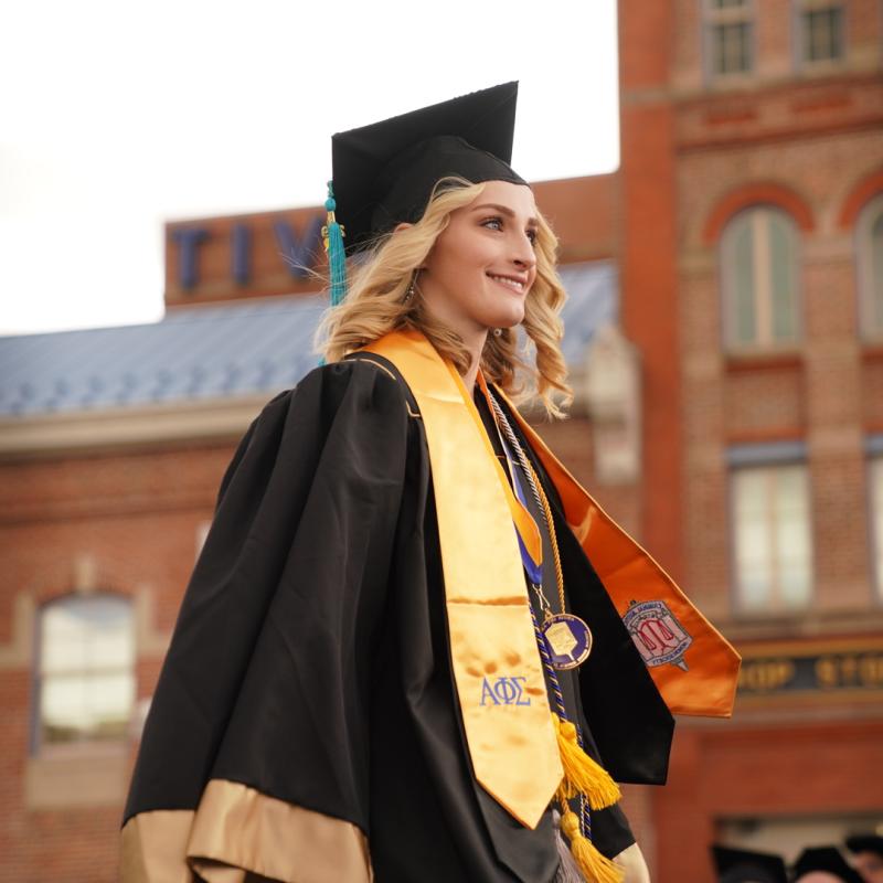 CU Denver student walking at commencement ceremony