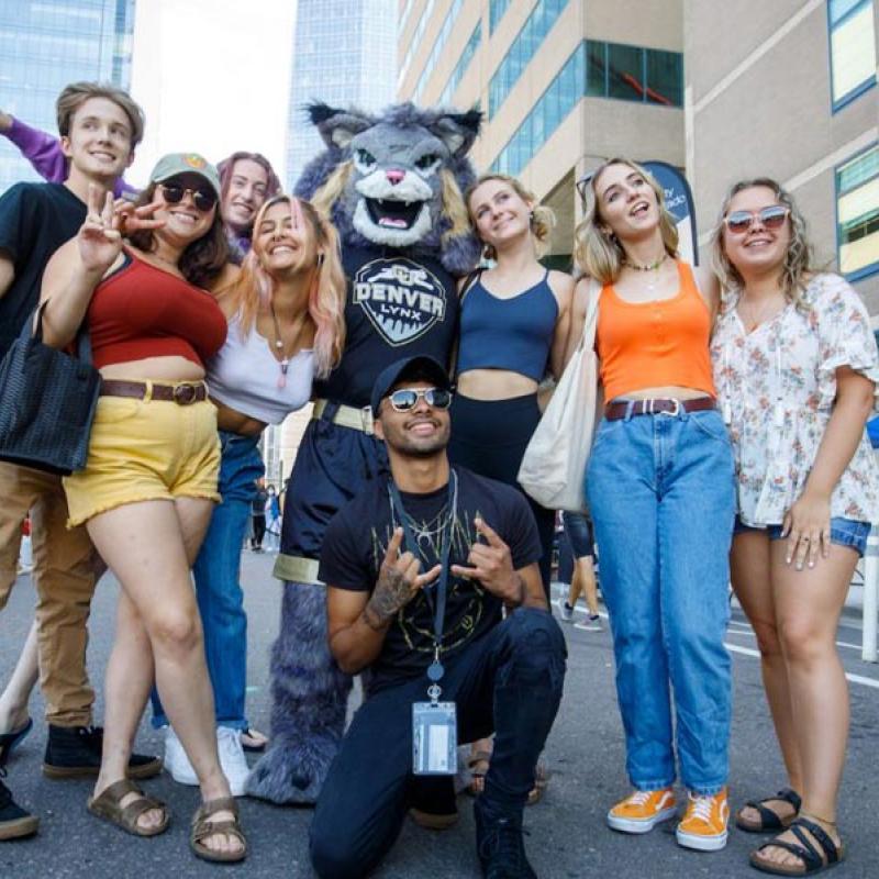 Group of CU Denver students at Block Party posing with mascot Milo