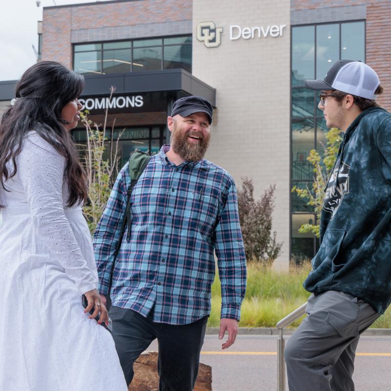 Three students standing outside of Student Commons