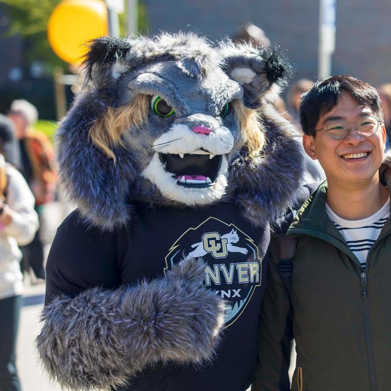 Student posing with CU Denver mascot