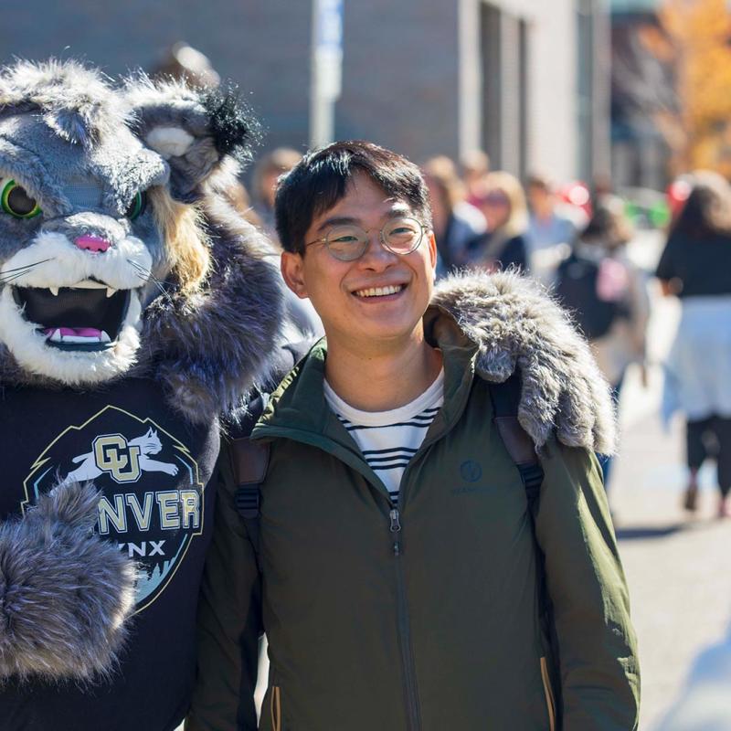 Student posing with CU Denver mascot