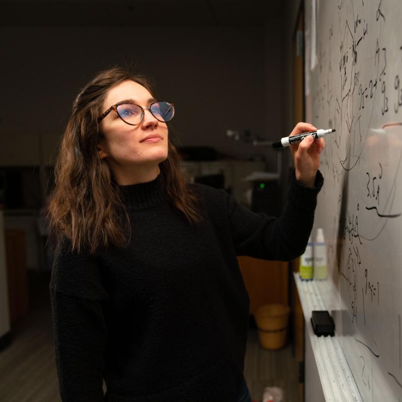 Student writing on whiteboard