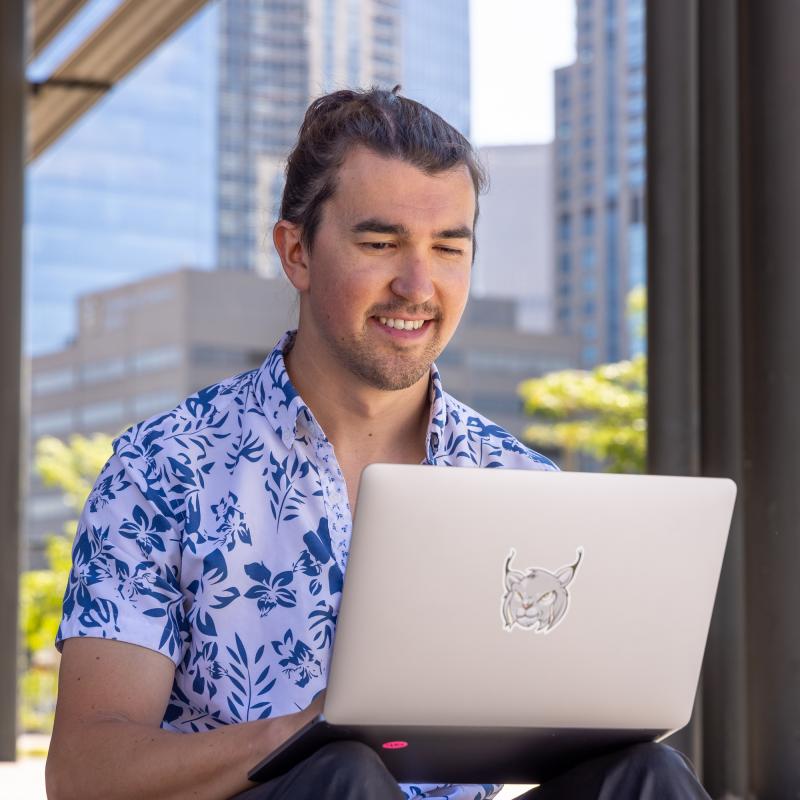 Student working on laptop outside