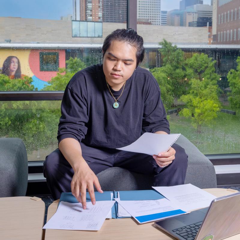 Student sitting at table looking at papers