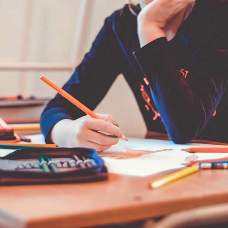 Person drawing with with an orange pencil